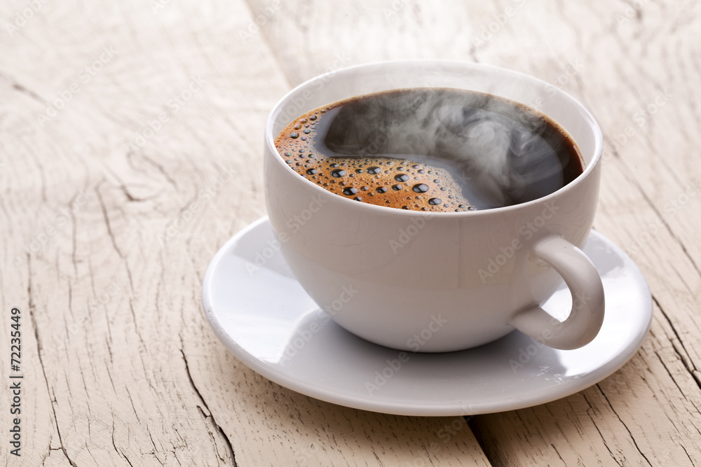 Obraz na płótnie Cup of hot coffee on an old wooden table. w salonie