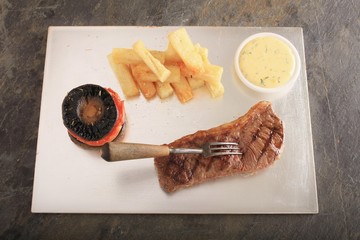 Canvas Print - sirloin steak on silver platter with chips  tomato and mushroom