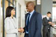 © michaeljung - indian businesswoman handshaking with african businessman