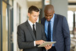 © michaeljung - two businessmen using tablet computer