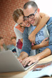 © goodluz - Cheerful couple websurfing on internet with laptop