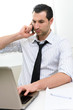 © Studio Gi - Businessman with laptop talking on the phone, selective focus