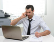 © Studio Gi - Businessman with laptop talking on the phone, selective focus