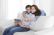 © Wordley Calvo Stock - young happy couple on sofa enjoying digital tablet computer
