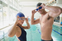 Fit Couple Swimmers By Pool At Leisure Center