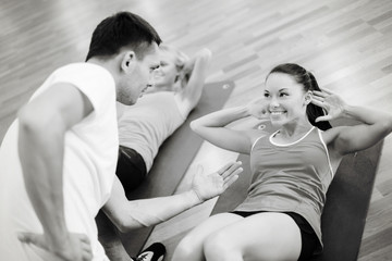 Wall Mural - group of smiling women doing sit ups in the gym