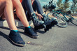 © LoloStock - Two women sitting by roadside wearing rollerblades