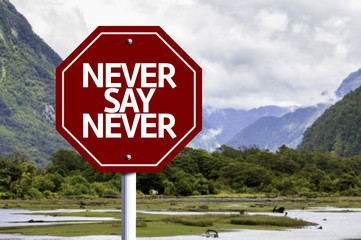Never Say Never written on red road sign
