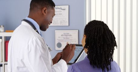 African American doctor taking patient history with tablet computer