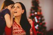 © WavebreakMediaMicro - Daughter telling her mother a christmas secret