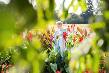 Wall Mural - beautiful young girl in a garden of flowers