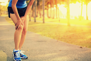 Wall Mural - woman runner hold her sports injured legs