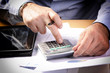 © pfpgroup - Businessman Using Calculator In Office