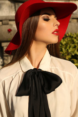 Wall Mural - beautiful woman with dark hair in elegant red hat