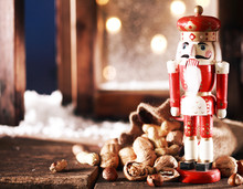 Nutcracker And Nuts On Wooden Table