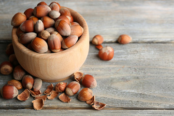 Wall Mural - Hazelnuts in wooden bowl on wooden background