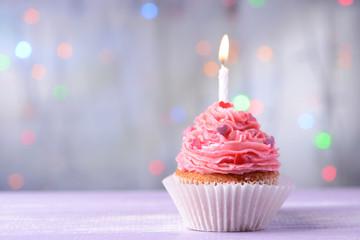 Wall Mural - Delicious birthday cupcake on table on light background