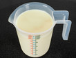 Half a liter of white milk in a transparent measurement plastic