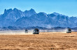 Landscape of Sahara desert with jeeps for safari.