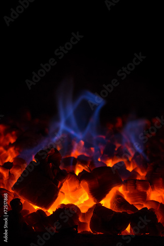 Closeup Of Glowing Hot Red Embers And Blue Flame In Fireplace