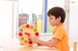 © wckiw - Little boy learning time with clock toy of montessori