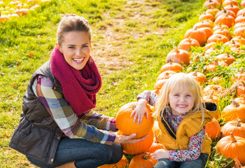 Wall Mural - Portrait of happy mother and child among pumpkin