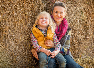 Wall Mural - Portrait of happy mother and child near haystack
