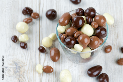 Fotomural chocolate covered nuts and raisins on wooden surface