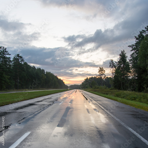 Fotografía wet asphalt road with sun reflections