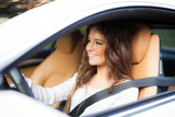 Fototapeta  - Smiling woman driving her car