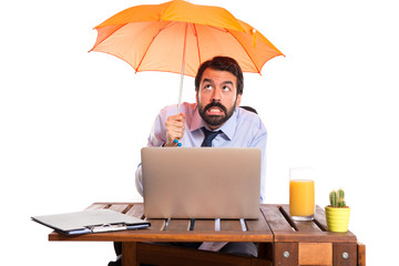 Wall Mural - Businessman in his office holding an umbrella