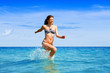 © nenadaksic - Young woman running through the sea water