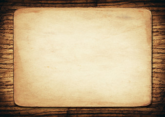 Old paper on dark wooden wall