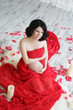Portrait of a beautiful pregnant woman in red chiffon shawl
