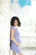 Pregnant woman with blue and white balloons