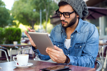 Modern young man with digital tablet in the street.