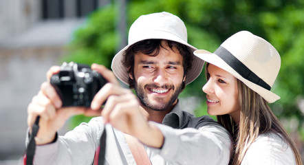 Wall Mural - Smiling tourist showing photos to his girlfriend