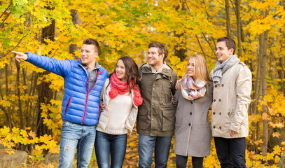 Wall Mural - group of smiling men and women in autumn park