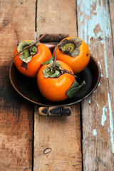 Wall Mural - Fresh ripe persimmon on a wooden table