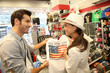 © goodluz - Couple of tourists in gift shop buying a shirt of New York City