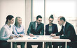 © Syda Productions - business team with documents having discussion