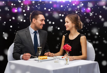 Canvas Print - smiling couple eating dessert at restaurant