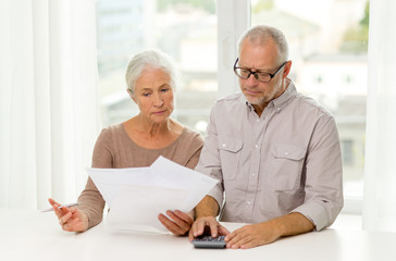 Poster - senior couple with papers and calculator at home