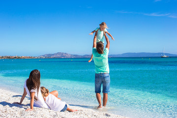 Young family of four during summer beach vacation