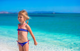 Fototapeta  - Adorable little girl at tropical beach during summer vacation