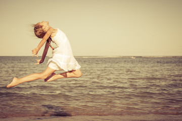 teen girl jumping on the beach at the day time