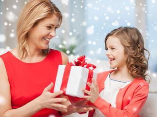 Poster - smiling mother and daughter with gift box at home