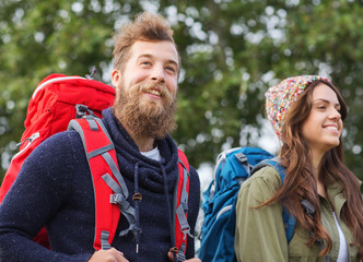 Canvas Print - group of smiling friends with backpacks hiking