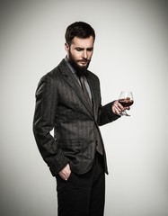 Wall Mural - Handsome well-dressed man in jacket with glass of beverage