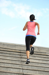 young fitness woman running up on stairs 